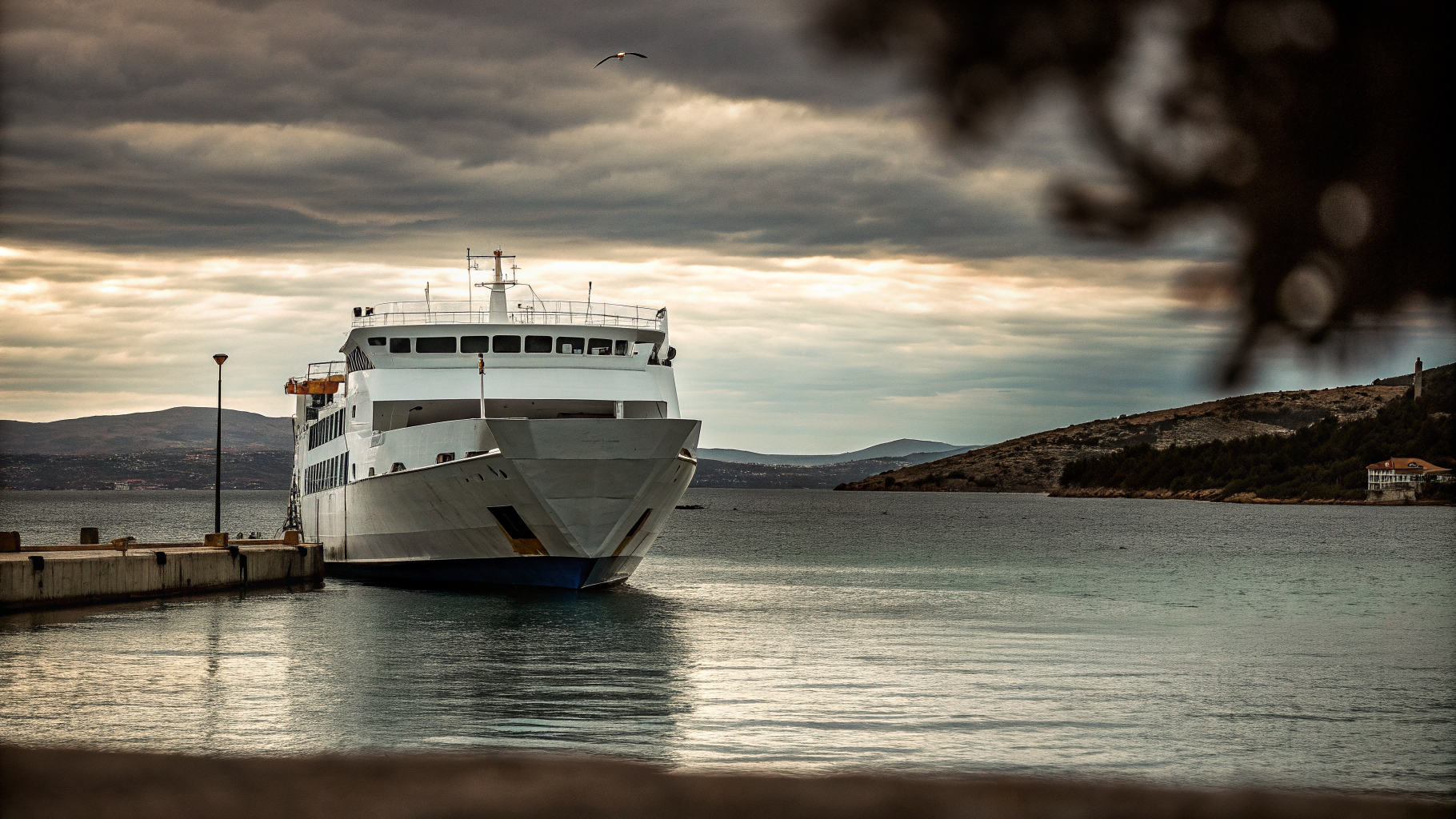 A white and blue Croatian car ferry leaving harbour under a moody autumn sky