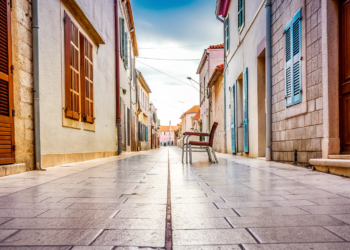 A quiet stone old-town street on a soft autumn morning in coastal Croatia