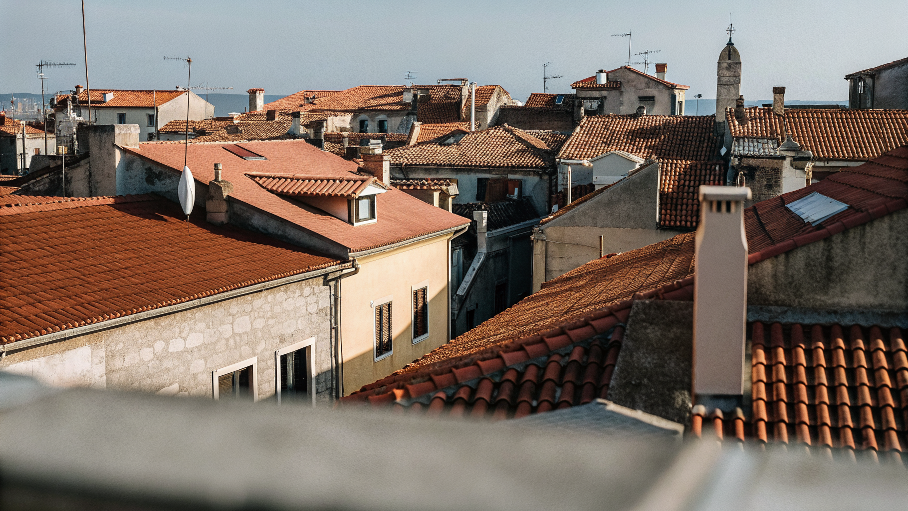 Illustration of Croatian old-town rooftops with some fading, symbolizing short-term rental listings leaving the market
