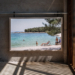A pebble beach on the Croatian coast with clear Adriatic water and light shade from pine trees