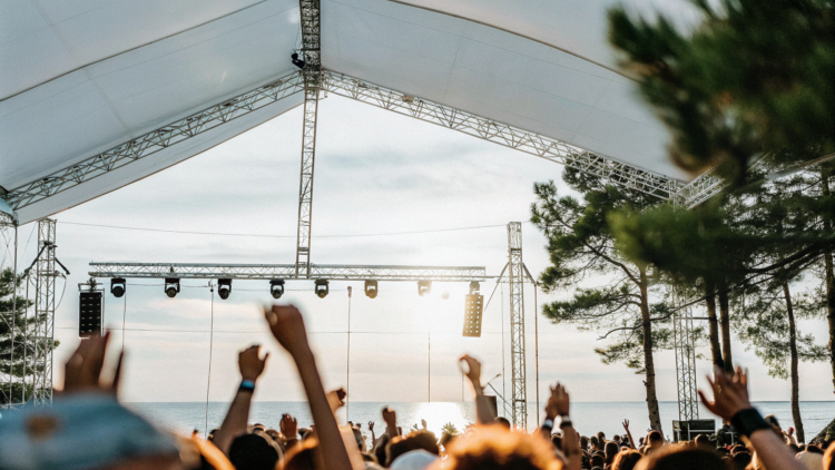 Crowd at an open-air summer music festival on the Croatian coast at dusk