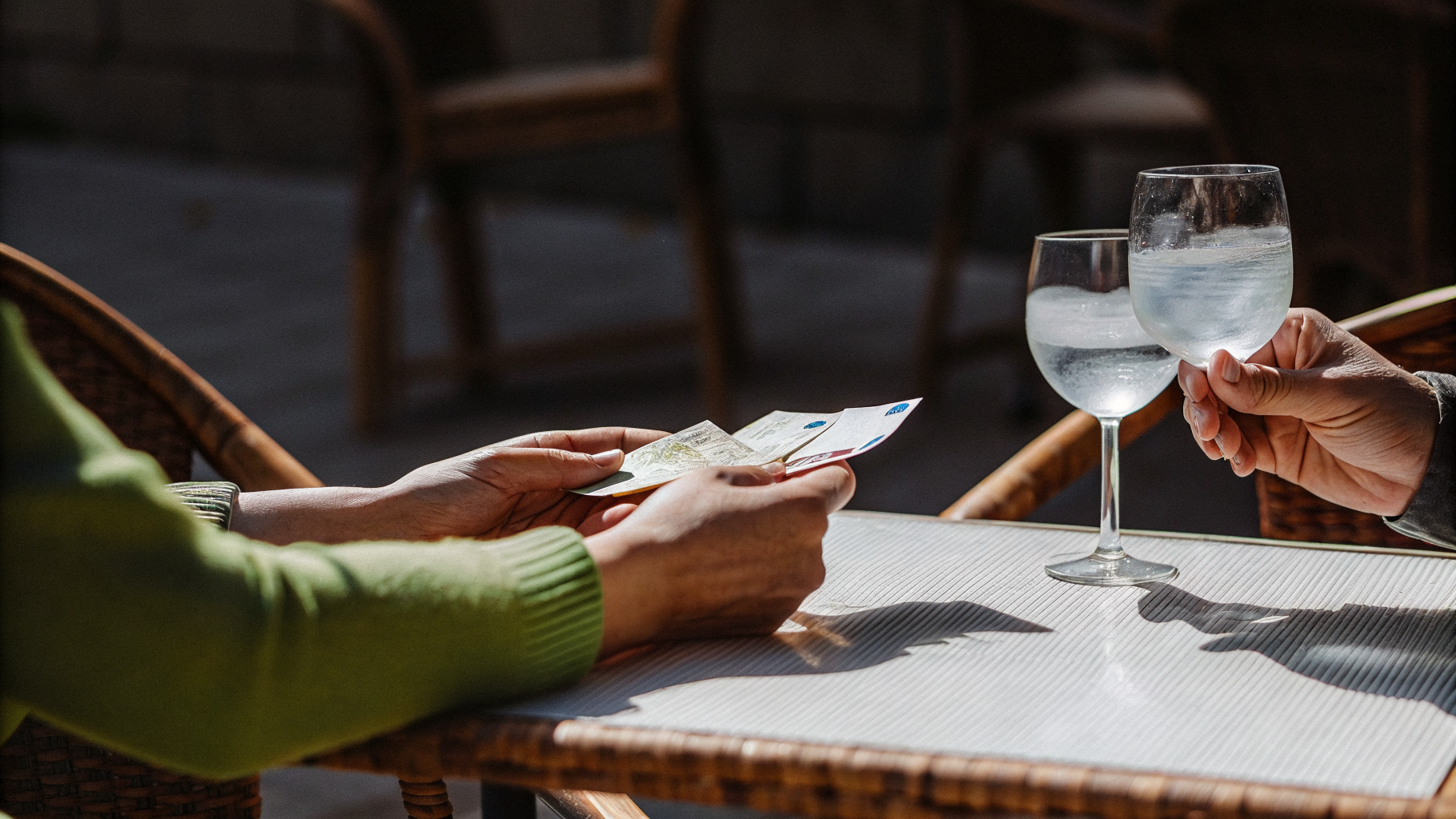 A traveller checking the printed bill at an outdoor bar table in Croatia before paying