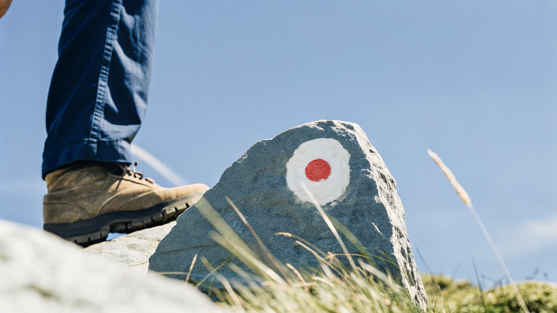 A white and red painted waymark on rock marking a hiking trail in Croatia