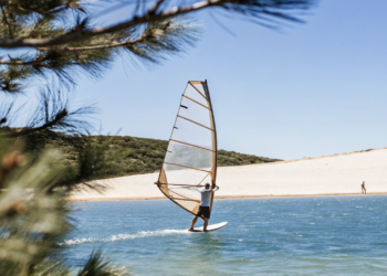 Windsurfer on the afternoon maestral off a pebble spit on Croatia's Adriatic coast near Bol