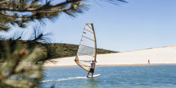 Windsurfer on the afternoon maestral off a pebble spit on Croatia's Adriatic coast near Bol