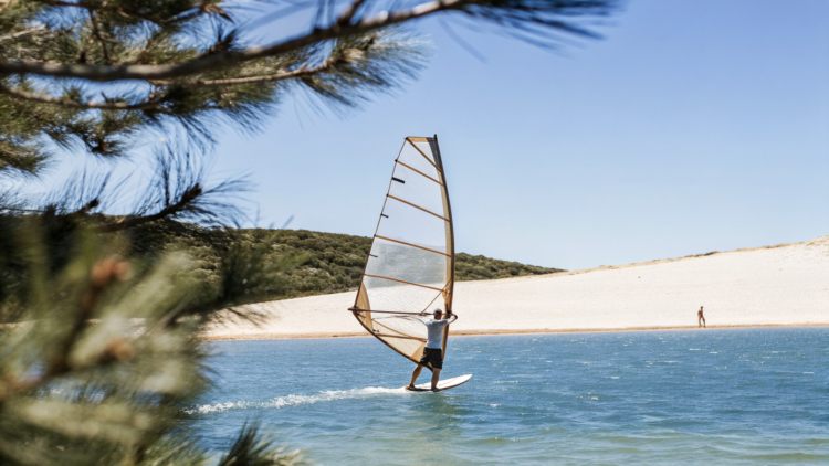 Windsurfer on the afternoon maestral off a pebble spit on Croatia's Adriatic coast near Bol