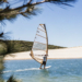 Windsurfer on the afternoon maestral off a pebble spit on Croatia's Adriatic coast near Bol