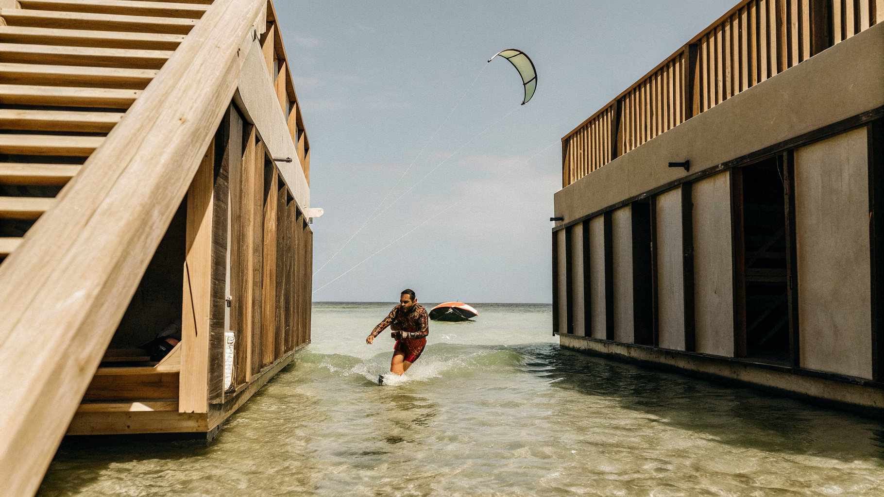Kitesurfer in an impact vest launching in shallow water with a rescue boat offshore in Croatia