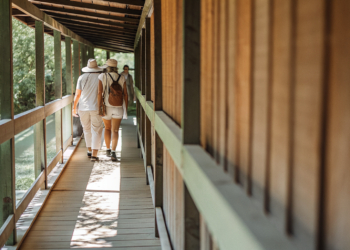 Visitors on a railless wooden boardwalk over turquoise water at a Croatian national park