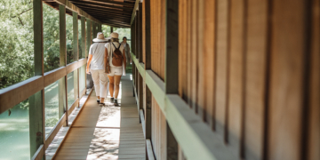 Visitors on a railless wooden boardwalk over turquoise water at a Croatian national park