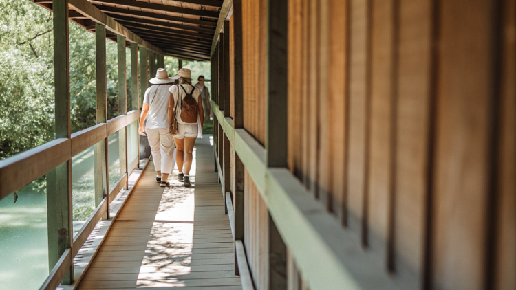 Visitors on a railless wooden boardwalk over turquoise water at a Croatian national park