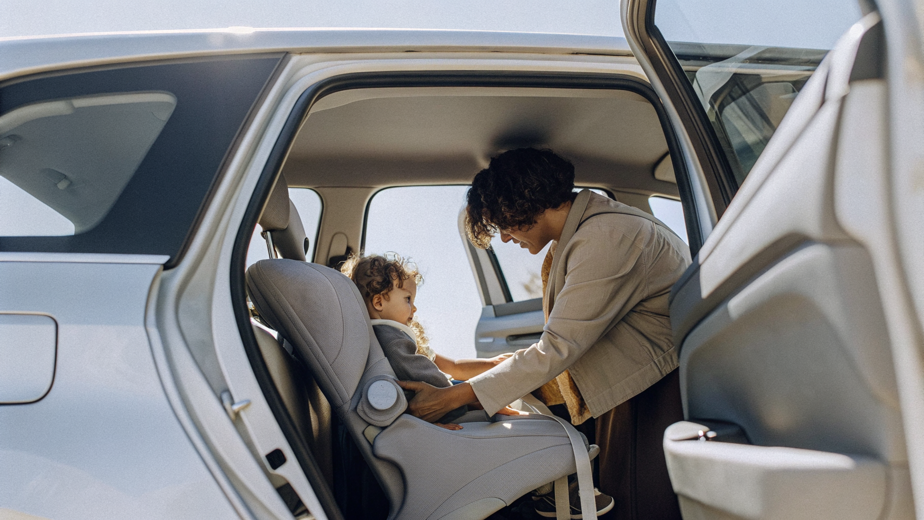 Parent securing a toddler into a properly fitted rear child car seat in Croatia