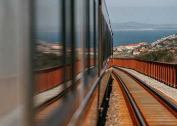 Illustration of a modern hybrid train travelling from Zagreb through the mountains toward Split