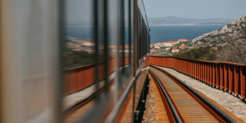 Illustration of a modern hybrid train travelling from Zagreb through the mountains toward Split