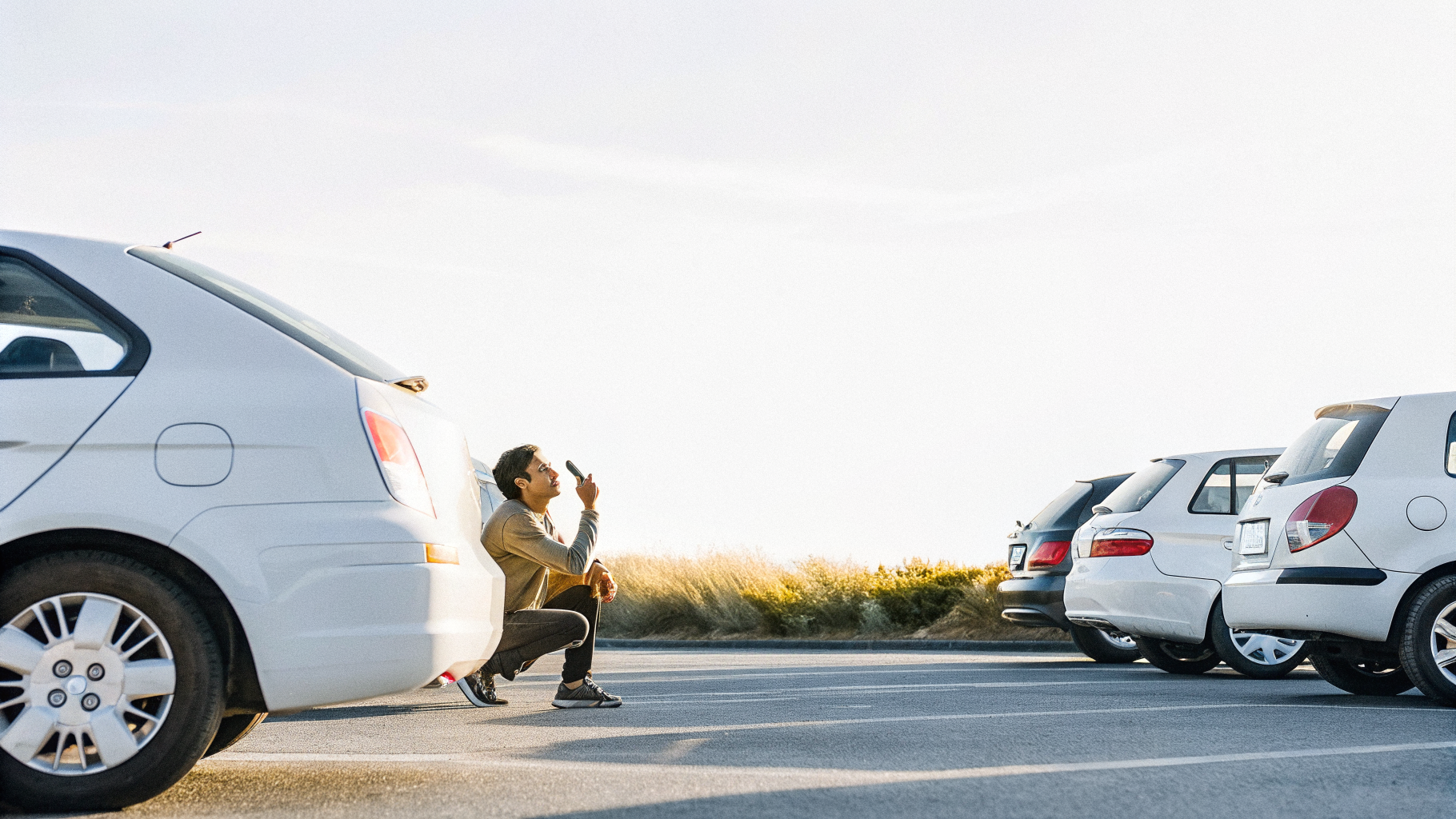 Photographing a scuffed bumper during the rental car walk-around before driving off